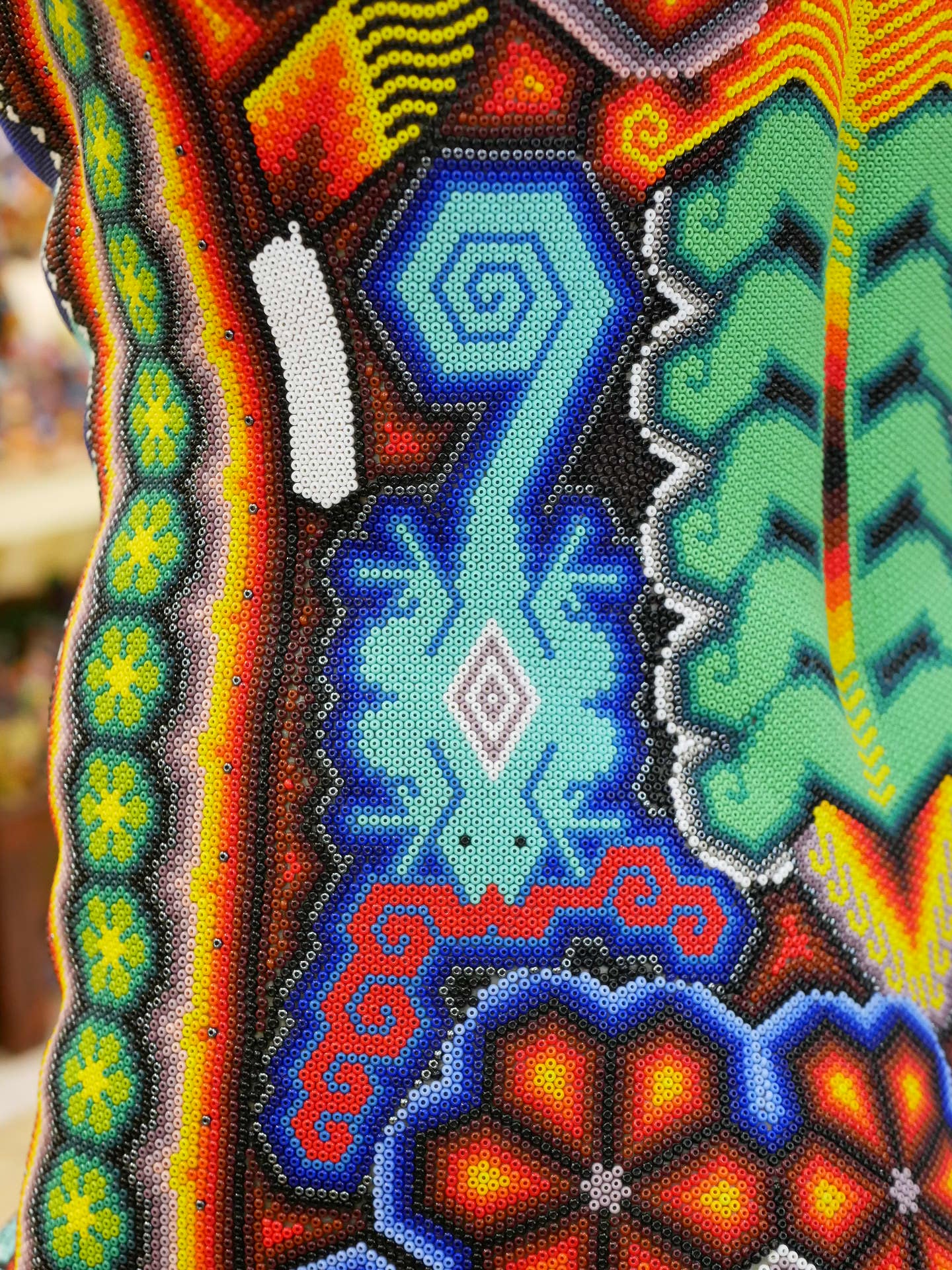 diseño de salamandra en obra de arte huichol en chaquira multicolor