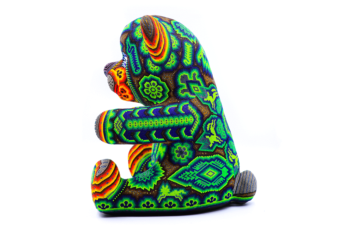 Oso Teddy Huichol decorado con mosaico de cuentas, mostrando patrones Wixárika detallados en una rica combinación de colores vibrantes.