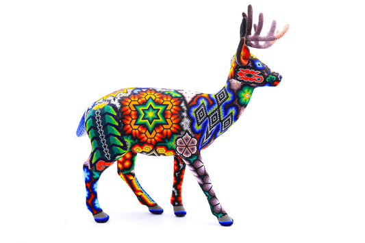 Escultura huichol de un ciervo con cuernos intrincadamente decorado con chaquiras en un vibrante patrón de colores, representando la iconografía y simbolismo wixárika, sobre una base artesanal.