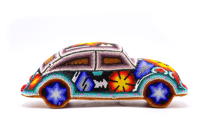 Réplica de un coche clásico en arte huichol, presentando un mosaico de chaquiras con intrincados diseños tradicionales