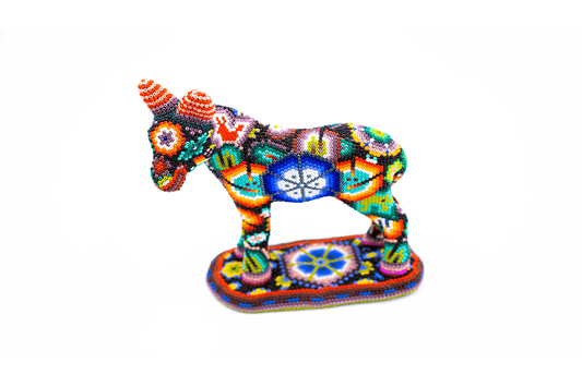 Escultura detallada de un burro huichol, visto de frente, con un mosaico de chaquiras formando diseños vibrantes y coloridos típicos del arte