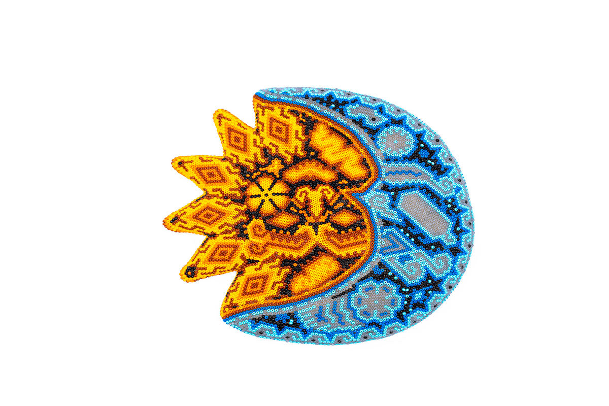 Obra de arte artesanal que representa un eclipse, creada con la técnica de chaquira en el estilo Huichol. La mitad izquierda muestra un sol en tonos cálidos de amarillo y naranja con patrones complejos, mientras la mitad derecha muestra la luna en tonos fríos de azul, creando un contraste visual que simboliza un eclipse