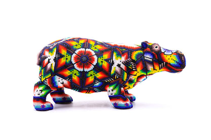 Escultura artística de hipopótamo Huichol con intrincados patrones de cuentas, representando el folclore y la artesanía Wixarika, ideal para decoración étnica del hogar