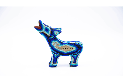 Estatuilla de lobo en posición erguida con detalles de cuentas coloridas, mostrando patrones geométricos complejos y un acabado brillante, contra un fondo blanco puro