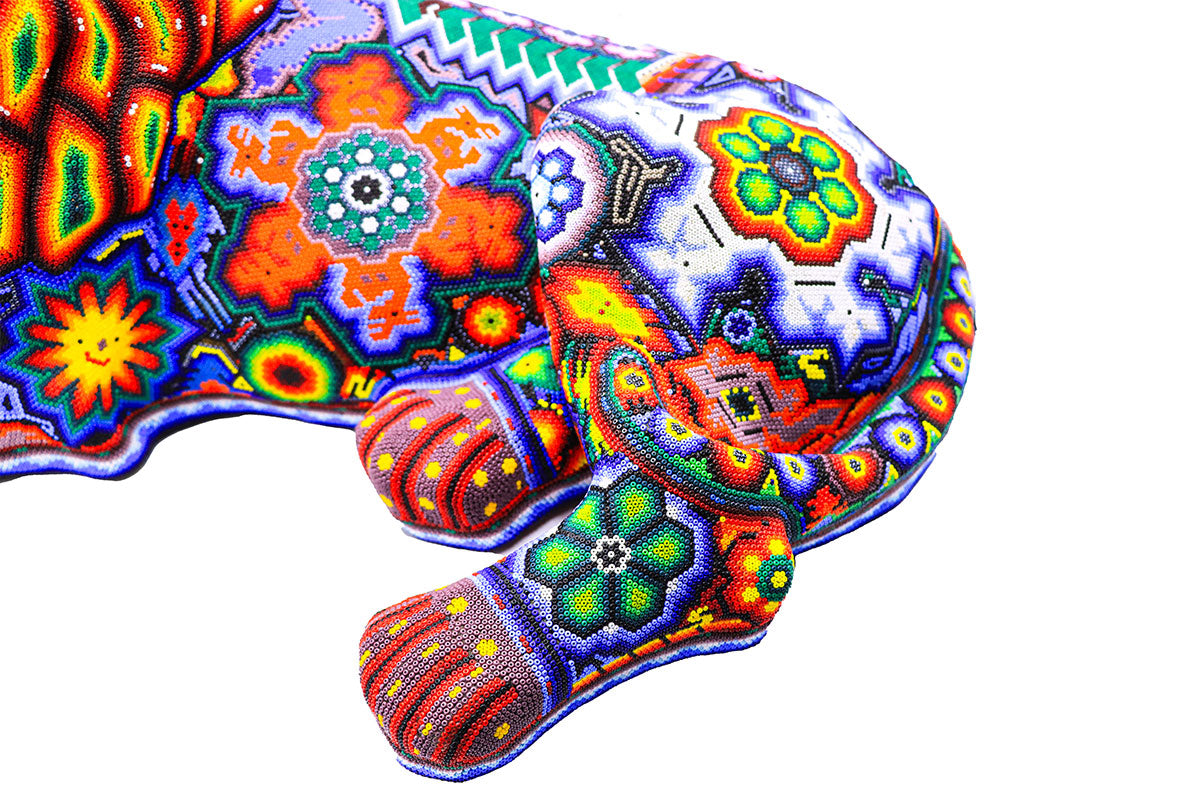 Escultura de león Huichol detallada, con diseño multicolor en chaquira, reflejando el arte y la cultura Wixárika, ideal para coleccionistas de arte étnico y decoración auténtica