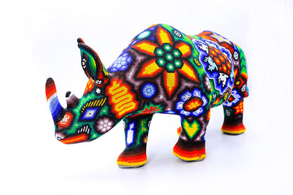 Rinoceronte de artesanía Wixárika, destacando por su colorido diseño de chaquiras que ilustran las tradiciones y el folclor de la cultura indígena de México