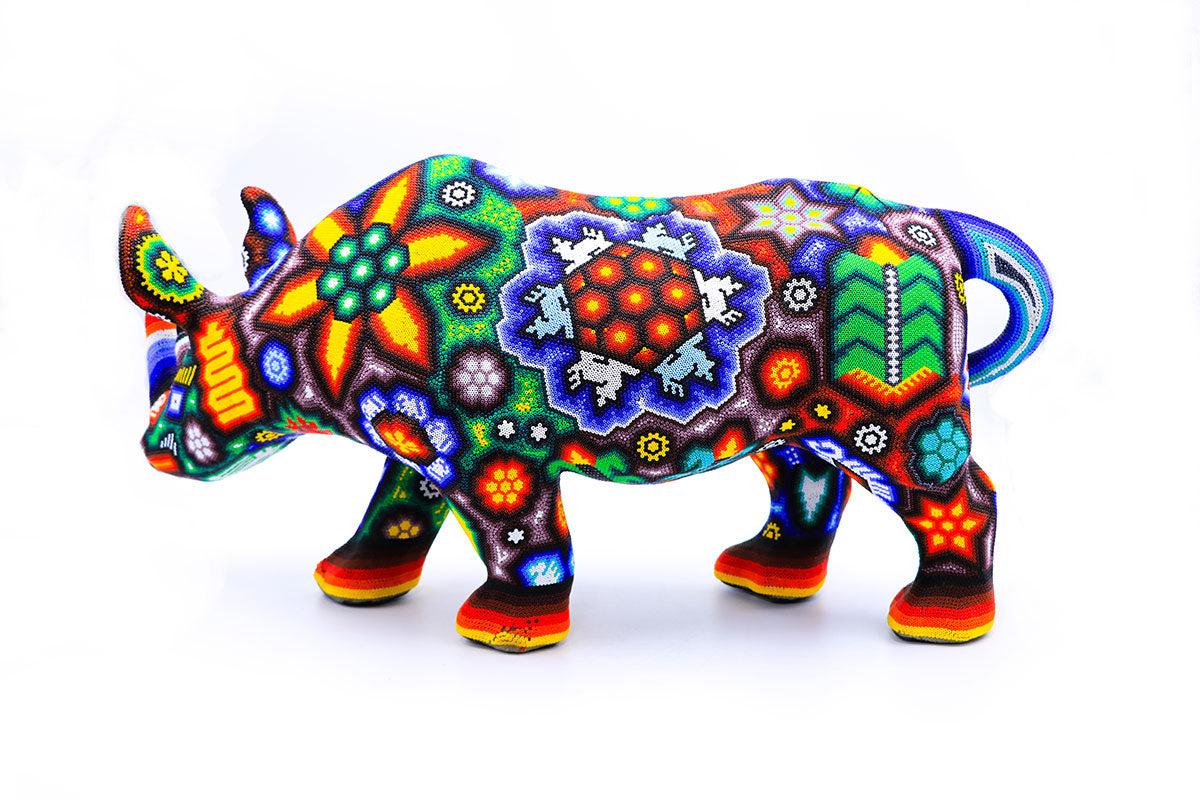 Obra de arte Huichol en forma de rinoceronte, cada cuenta colocada a mano crea un vibrante tapiz de formas y símbolos sagrados de la tribu Wixárika