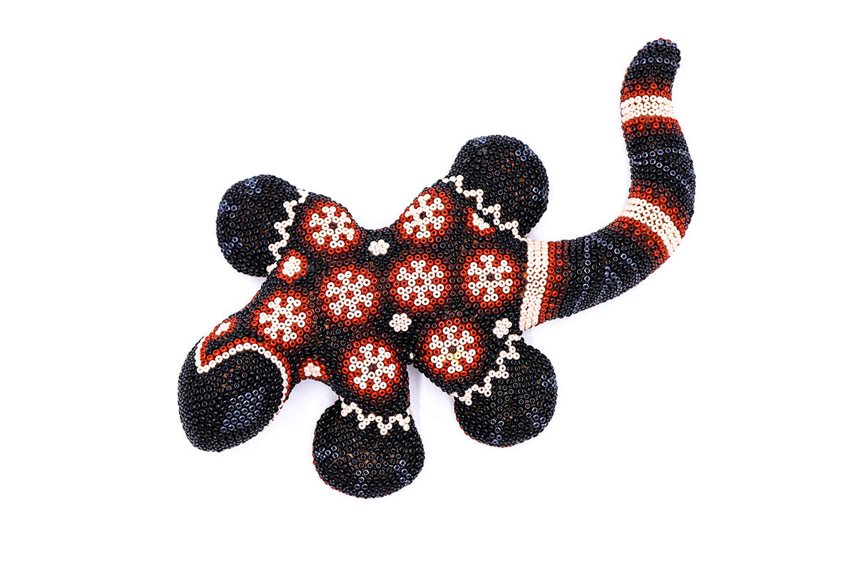 Arte Huichol representado en una figura de salamandra decorada con un mosaico de cuentas finas, mostrando la habilidad artesanal Wixarika en una obra de arte única para decoración del hogar o regalo cultural