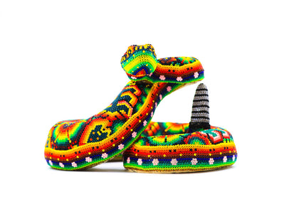Artesanía Wixárika de una serpiente, con un patrón detallado de chaquira que refleja la rica paleta de colores y simbolismo de la cultura Huichol