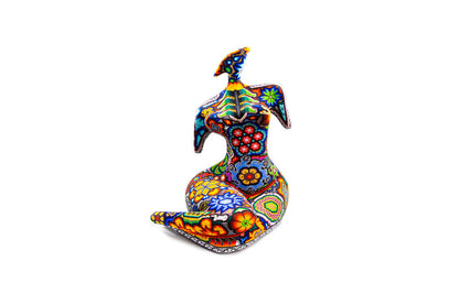 Artesanía de un torso femenino vista de frente, con detallados patrones de chaquira representando la artesanía Huichol. La pieza combina colores vivos y formas geométricas y florales, ofreciendo un mosaico colorido que captura la mirada