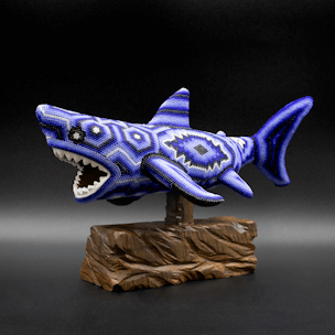 Shark sculpture with blue beads on a wooden base